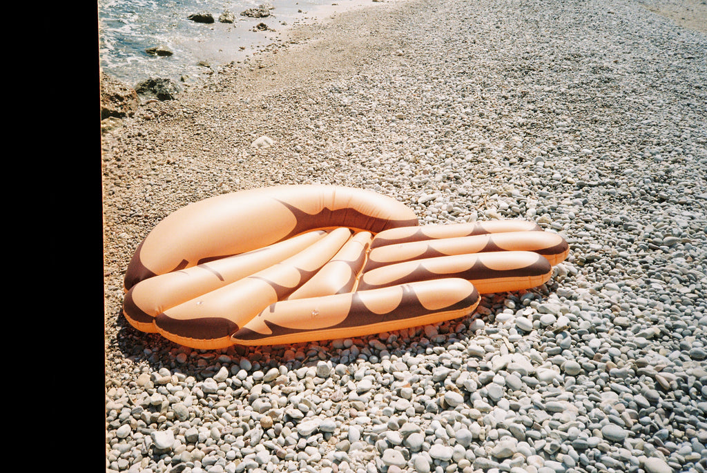 mano gigante flotador toi en la playa